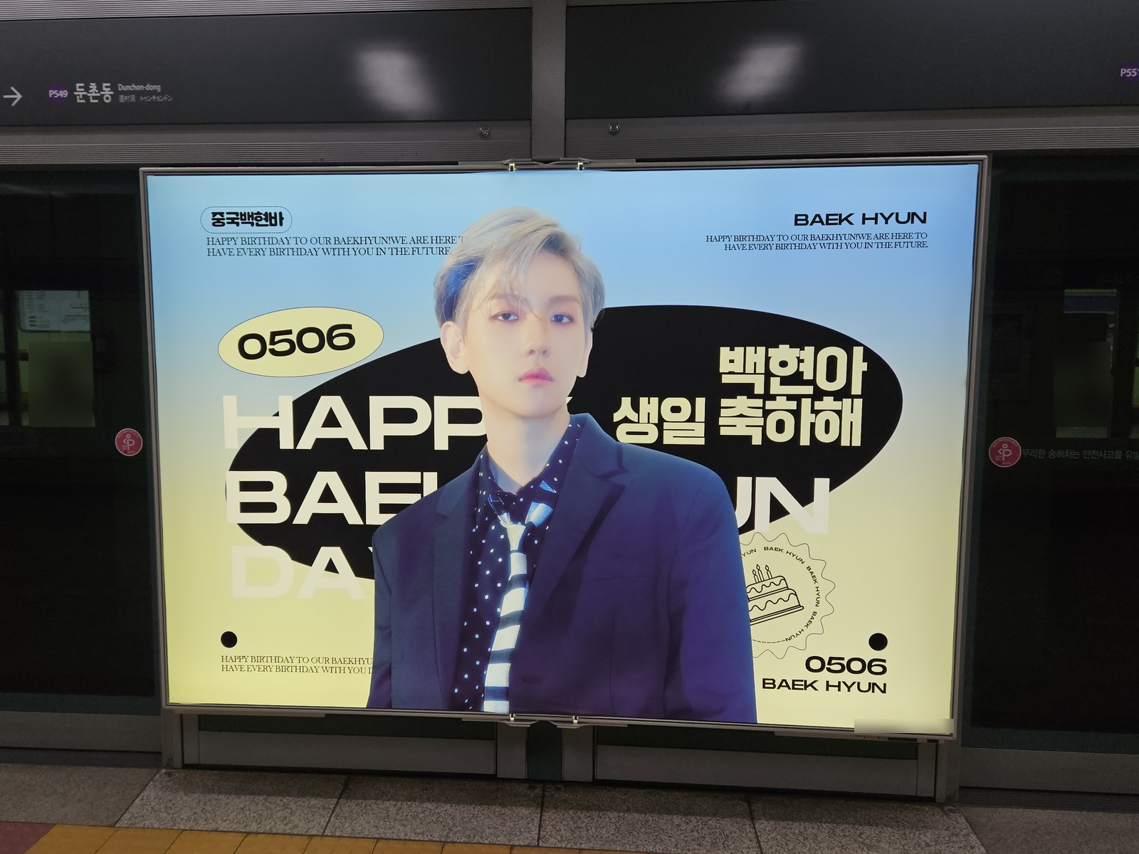 Sky blue and pale yellow screen door panel reading HAPPY BAEKHYUN DAY with the date 0506