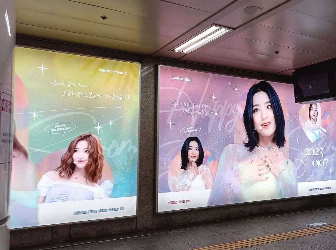 Both lightboxes seen from the other end of the wall, with handwritten-style Korean lines on each panel