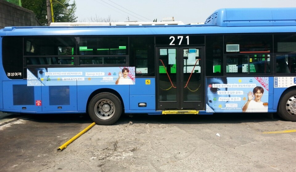 Door side of the same bus with a narrow banner near the back and a larger panel next to the door, both in the same pixel design