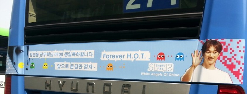 Rear of the bus with a strip ad showing the Korean birthday message, Forever H.O.T. and the line White Angels Of China