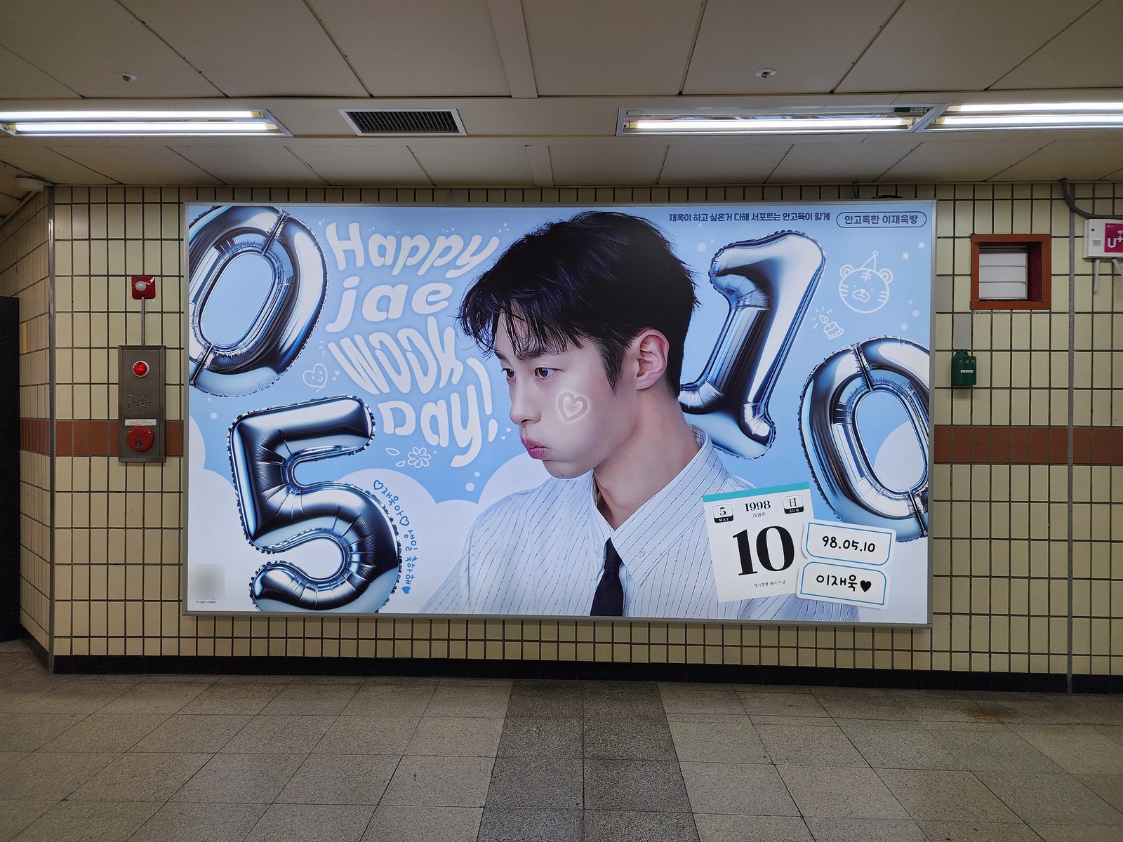 Lee Jae-wook birthday ad on a wide subway lightbox, with silver balloon numbers 0510 and the words Happy jae wook Day! on a sky-blue background