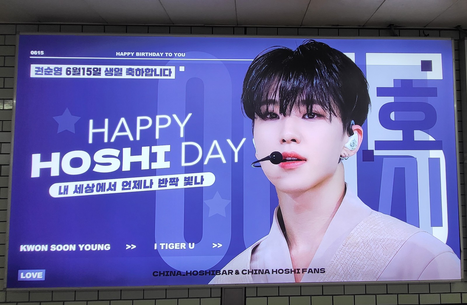 SEVENTEEN Hoshi birthday ad on a large purple lightbox at Samseong Station reading HAPPY HOSHI DAY